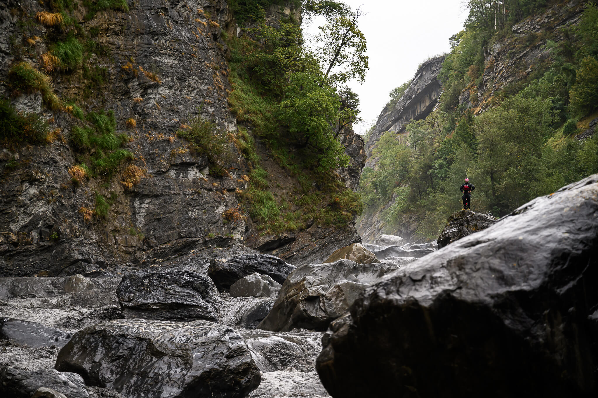 ubayak-02-ubaye-gorge-high-water-by-cedric-eyma The Ubaye gorge in the rain, a small figure standing on a boulder above the high, grey water